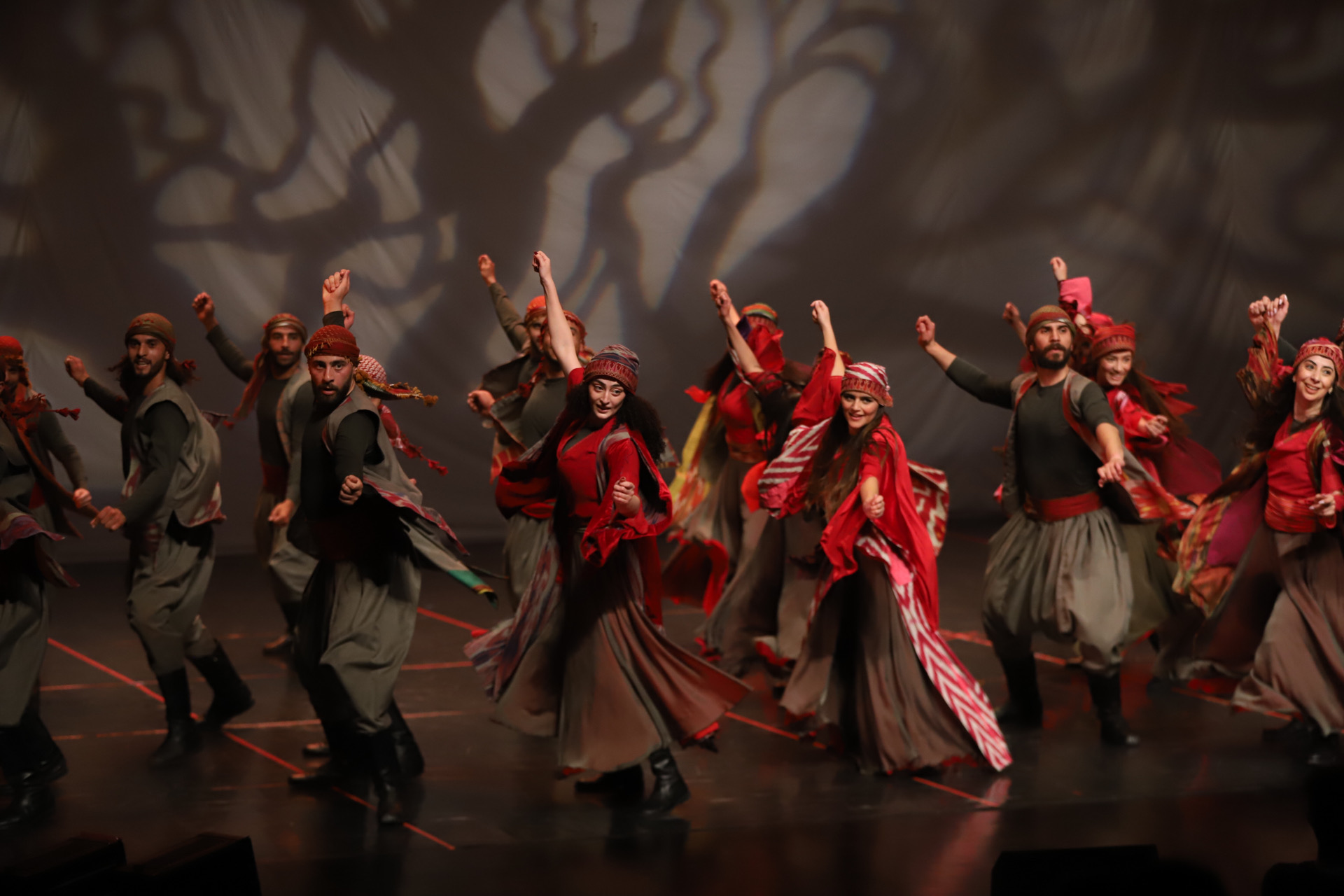 A group of female and male dancers dressed in traditional Palestinian garments and headpieces